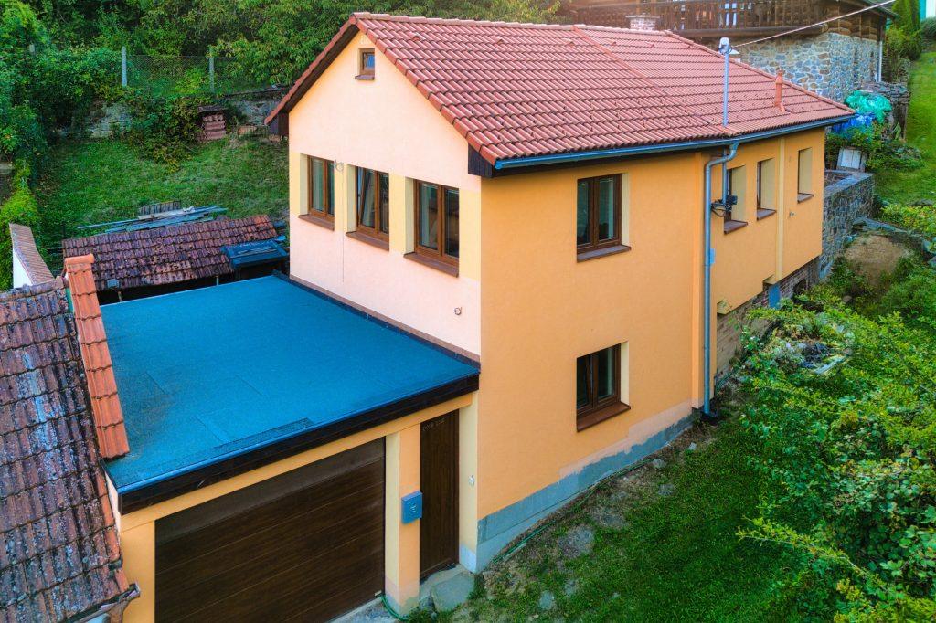 Vyšší dronový pohled ukazuje širší polohu domu.