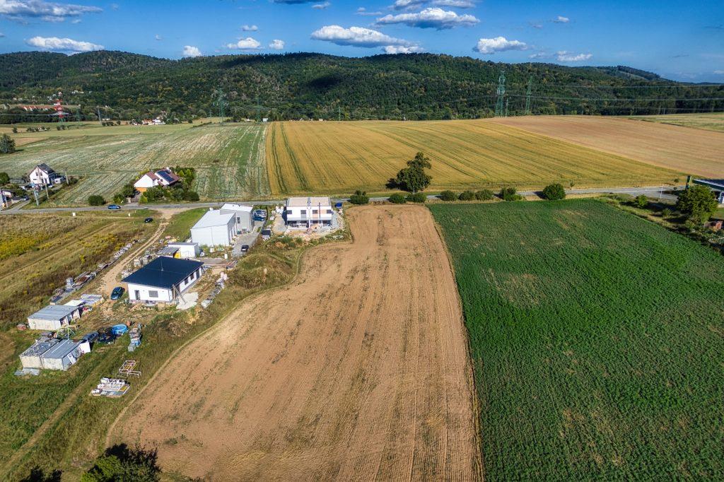 Dronový záběr doplňuje okolí pozemku a krajinný kontext.